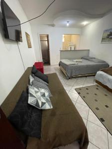 a bedroom with two beds and a flat screen tv at Apto Antonio Centro in Campos dos Goytacazes +6 photos