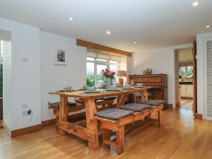 a dining room with a wooden table and benches at Waterland Farmhouse in Holsworthy