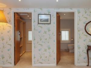 a bathroom with white walls and blue flowers on the wall at Waterland Farmhouse in Holsworthy +37 photos