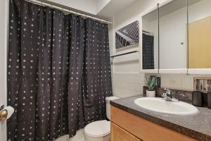 a bathroom with a sink and a shower curtain at Prime 2-Bedroom Oasis - Church 304 in Evanston