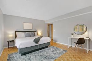 a bedroom with a bed and a desk and a mirror at Prime 2-Bedroom Oasis - Church 304 in Evanston