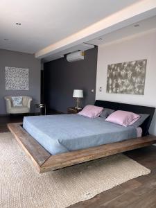 a bedroom with a large bed with pink pillows at Luxury Palms Puerto Arista in Puerto Arista