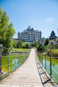 a bridge over a river with a building in the background at Etno selo Stanišići Hotel Pirg in Dvorovi