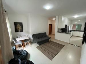 uma sala de estar com um sofá e uma mesa em Apartamento Aconchegante em Capitólio