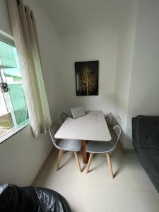 a white table with two chairs and a laptop on it at Apartamento Aconchegante in Capitólio