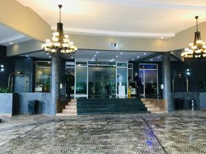 a lobby of a building with two chandeliers at Golden Tulip Ibadan in Ibadan