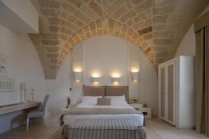 una camera da letto con un grande letto e un soffitto in pietra di Baglioni Masseria Muzza a Otranto