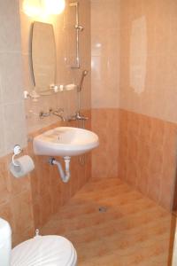 a bathroom with a sink and a toilet and a mirror at Family Hotel Sinemoretz in Sinemorets