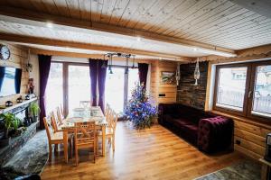 a living room with a table and chairs and a christmas tree at Domek na Zakręcie in Zakopane