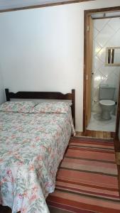 a bedroom with a bed and a bathroom with a toilet at Pousada Sobre as Ondas - ILHA DO MEL - PR in Ilha do Mel