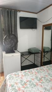 a room with a bed and a television and a bed sidx sidx sidx at Pousada Sobre as Ondas - ILHA DO MEL - PR in Ilha do Mel