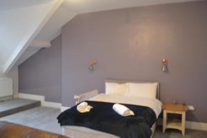 a bedroom with a bed with black blanket and white pillows at Ashbrooke Homestay in Sunderland