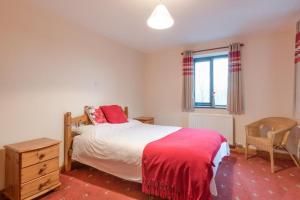 a bedroom with a bed and a chair and a window at 3 Bed in Threlkeld SZ433 in Threlkeld
