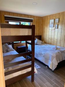 a bedroom with two bunk beds in a room at Refugio del bosque in Futrono