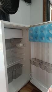an empty refrigerator with its door open in a room at Pousada Sobre as Ondas - ILHA DO MEL - PR in Ilha do Mel