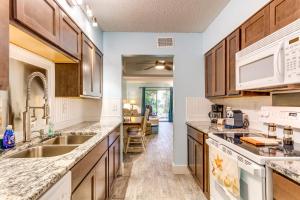a kitchen with wooden cabinets and a sink at Central Mary Esther Condo 5 Mi to Okaloosa Island! in Mary Esther