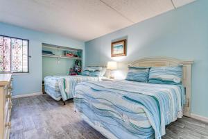 two beds in a bedroom with blue walls at Central Mary Esther Condo 5 Mi to Okaloosa Island! in Mary Esther +23 photos