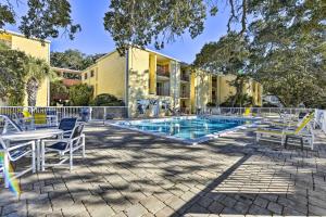 an exterior view of a house with a pool and chairs at Central Mary Esther Condo 5 Mi to Okaloosa Island! in Mary Esther