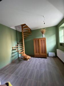 a room with a staircase and a green wall at Entzückendes Häuschen, neu ren. in Groß-Siegharts