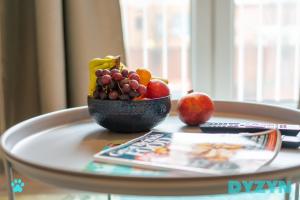 a bowl of fruit on a table with a magazine at WiFi | Parking | Comfort in Cardiff