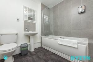 a bathroom with a toilet a sink and a bath tub at WiFi | Parking | Comfort in Cardiff