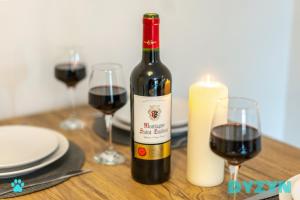 a bottle of red wine sitting on a table with glasses at WiFi | Parking | Comfort in Cardiff