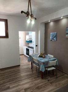 ein Esszimmer mit einem Tisch und Stühlen sowie eine Küche in der Unterkunft Casa 100m dal mare caraibico in Lido Marini