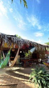 a patio with hammocks and a thatch roof at CASA AUM in Brisas de Zicatela