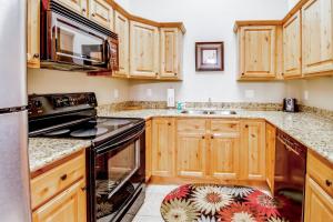 La cuisine est équipée de placards en bois et d'un four avec plaques de cuisson. dans l'établissement Red Cliff 3J, à Moab