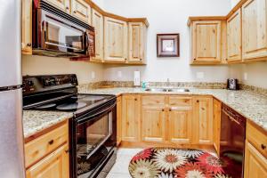 a kitchen with wooden cabinets and a stove top oven at Red Cliff 3J in Moab