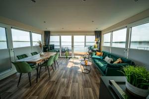 a living room with a green couch and a table at Hausboot Albatros - LP4 in Laasow