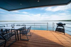 a table and chairs on the deck of a boat at Hausboot Albatros - LP4 in Laasow