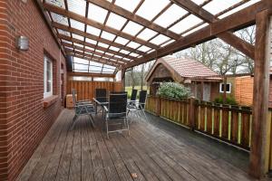 a pergola on a deck with a table and chairs at Ferienhaus Auszeit in Westoverledingen