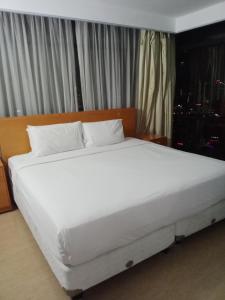 吉隆坡的住宿－BBS APARTMENT AT TIMES SQUARE KUALA LUMPUR MALAYSIA，卧室内的一张带白色床单和枕头的床