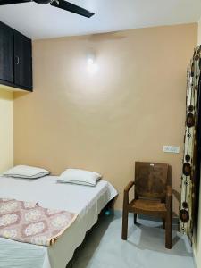 a bedroom with two beds and a chair at Shivoham Homestay(शिवोहम होमस्टे) in Ujjain