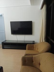 sala de estar con silla y TV de pantalla plana en BBS APARTMENT AT TIMES SQUARE KUALA LUMPUR MALAYSIA en Kuala Lumpur