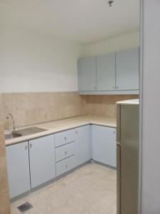 a kitchen with white cabinets and a stainless steel refrigerator at BBS APARTMENT AT TIMES SQUARE KUALA LUMPUR MALAYSIA in Kuala Lumpur