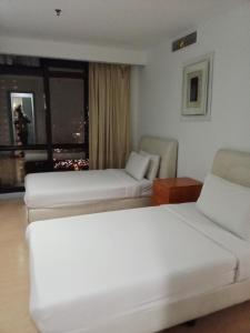 a hotel room with two beds and a window at BBS APARTMENT AT TIMES SQUARE KUALA LUMPUR MALAYSIA in Kuala Lumpur