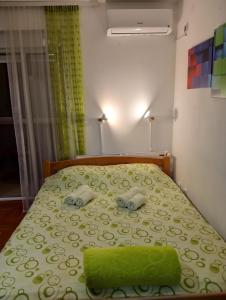 Schlafzimmer mit einem Bett mit grüner Tagesdecke in der Unterkunft Apartman Radmanovac 2 in Vrnjačka Banja
