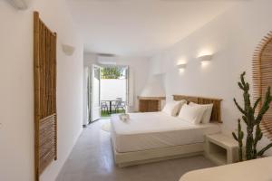 a white bedroom with a bed and a table at ACOYA SUMMER HOME in Kampos Paros