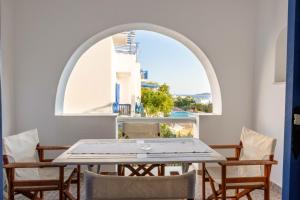 a table and chairs in a room with a window at ACOYA SUMMER HOME in Kampos Paros