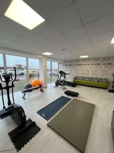 une salle de sport avec plusieurs tapis de course et machines elliptiques dans l'établissement Mercure Dieppe La Présidence, à Dieppe