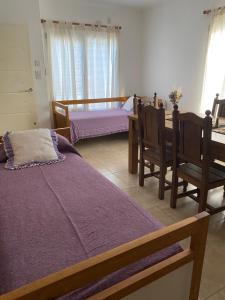 a bedroom with two beds and a table and chairs at Complejo Pampa 1 in Santa Rosa