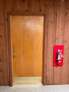 Przy drewnianych drzwiach znajduje się czerwony hydrant pożarowy. w obiekcie Slifer Street Studio #11 w mieście Portage
