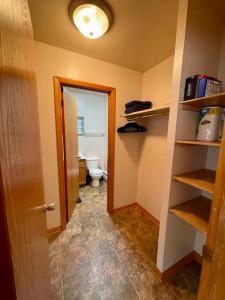 a bathroom with a toilet and a hallway with shelves at Slifer Street Studio #11 in Portage