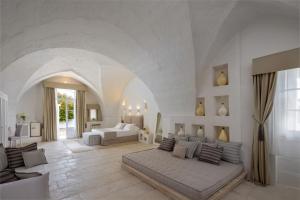 Großes weißes Zimmer mit einem Bett und einem Sofa in der Unterkunft Baglioni Masseria Muzza Resort & Spa in Otranto