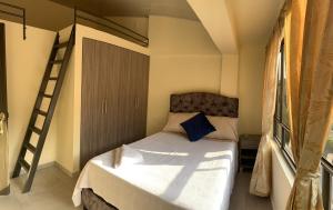 um pequeno quarto com uma cama e uma escada em Posada RoRi em Choachí