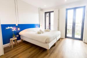 a bedroom with a large white bed with blue walls at Guest H4U - Heroismo in Porto