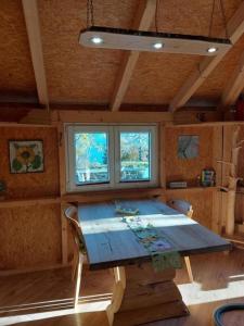 una gran mesa de madera en una habitación con ventanas en Einzigartige Holzhütte en Beatenberg