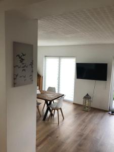 d'une salle à manger avec une table et une télévision à écran plat. dans l'établissement Schöfferles Ferienwohnung, à Keidelheim